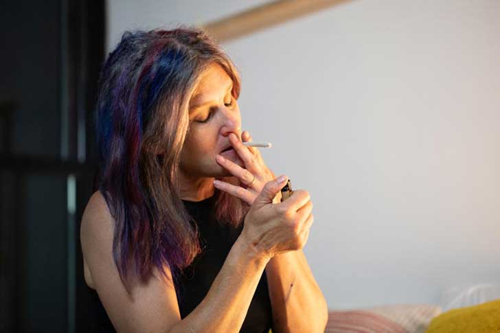 A woman smokes a joint