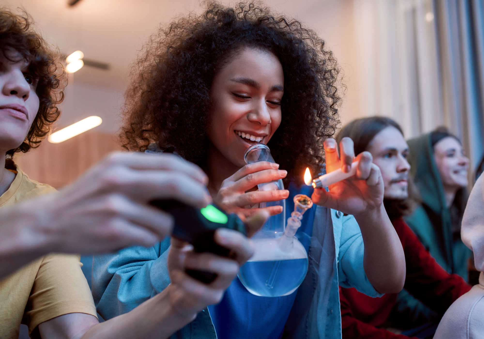 Woman lighting marijuana in a glass bong.