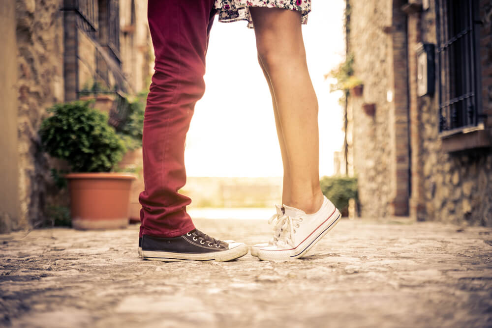 A couple kissing in an alley