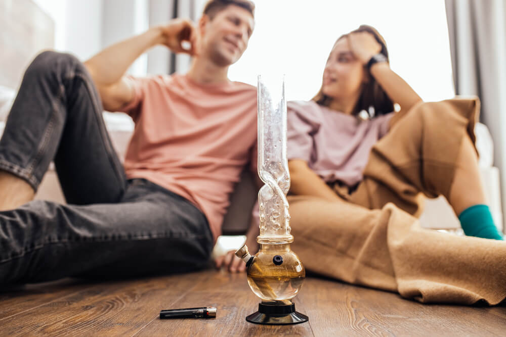 A couple smoking cannabis in the bedroom