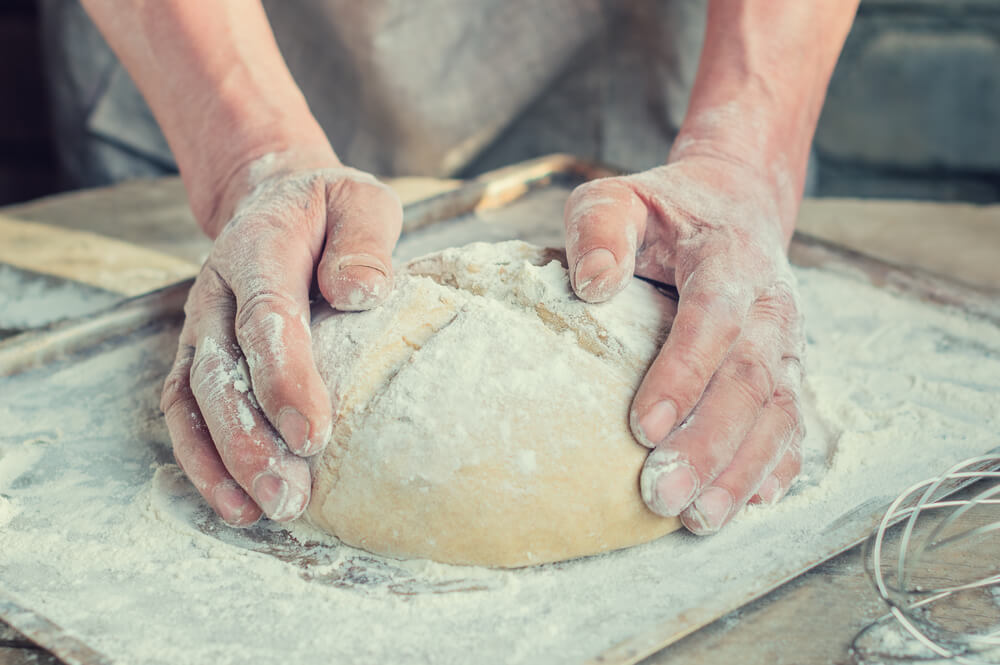 Shaping a loaf of cannabis infused bread before putting it into the oven.