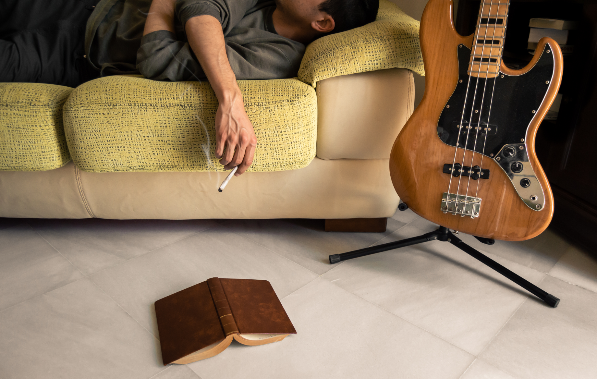 Young man laying on a couch smoking a joint